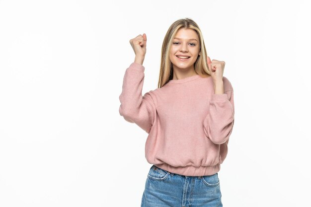 Mujer muy feliz celebrando su éxito con las manos levantadas aisladas en la pared blanca