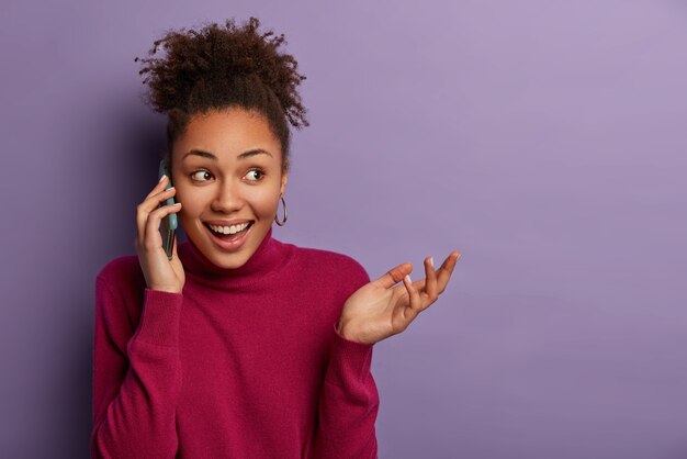 Mujer muy feliz con expresión positiva sorprendida tiene conversación amistosa