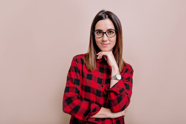 Mujer muy inteligente vestida con camisa y gafas, mirando con satisfacción al frente, siendo feliz