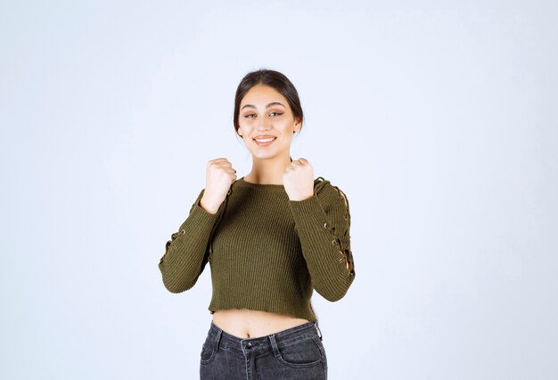 Mujer muy sonriente que se siente feliz sobre fondo blanco.