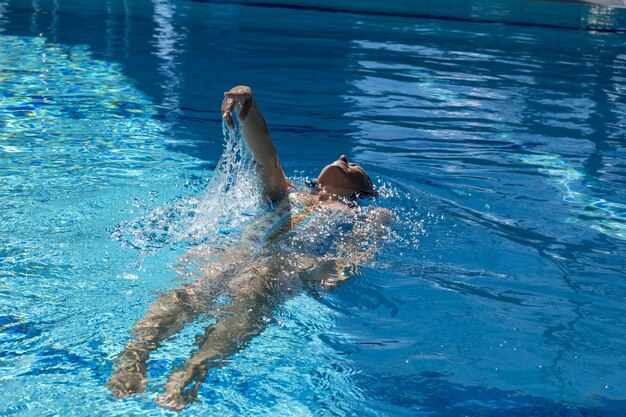 Mujer nadando en la piscina durante el día