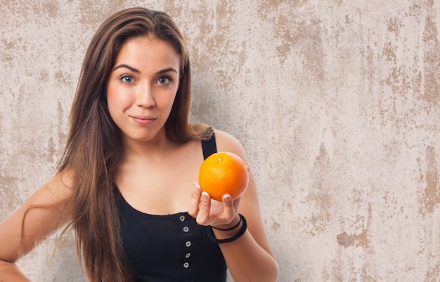 Foto gratuita mujer con una naranja en la mano