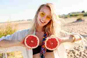 Foto gratuita mujer natural rubia feliz con pomelo. comida de dieta saludable. vacaciones de verano .