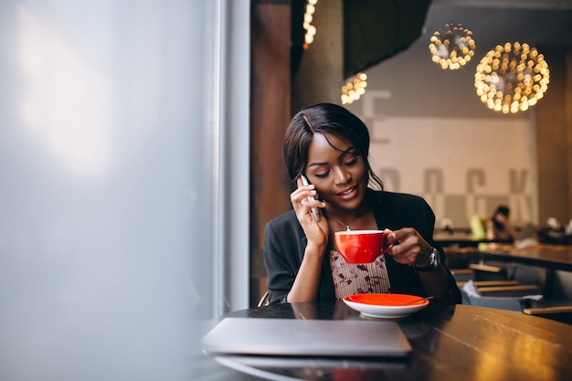 Mujer de negocios afroamericana que trabaja en un café