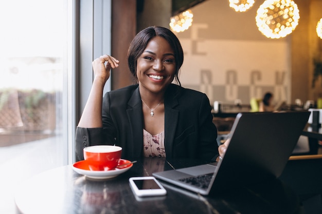 Mujer de negocios afroamericana que trabaja en un café