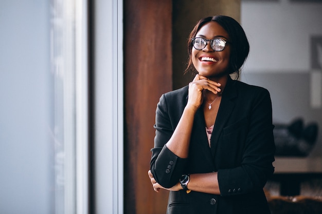 Mujer de negocios afroamericana por la ventana