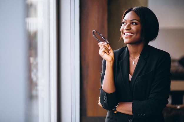 Mujer de negocios afroamericana por la ventana