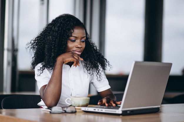 Mujer de negocios afroamericano con computadora y café
