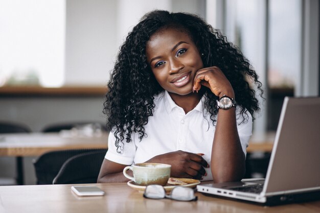 Mujer de negocios afroamericano con computadora y café