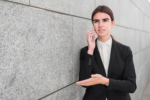 Mujer de negocios al lado de pared