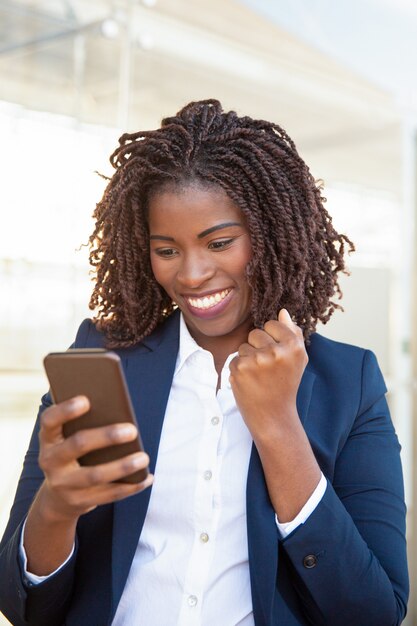 Mujer de negocios alegre feliz con teléfono celular