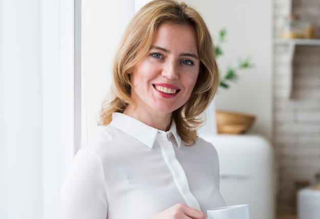 Mujer de negocios alegre con la taza de café