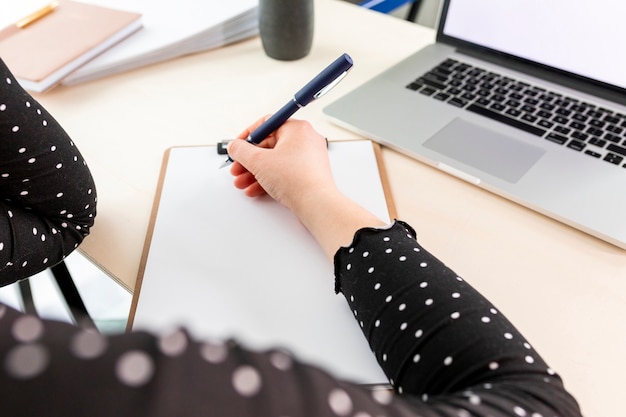 Foto gratuita mujer de negocios de alto ángulo tomando notas en el portapapeles