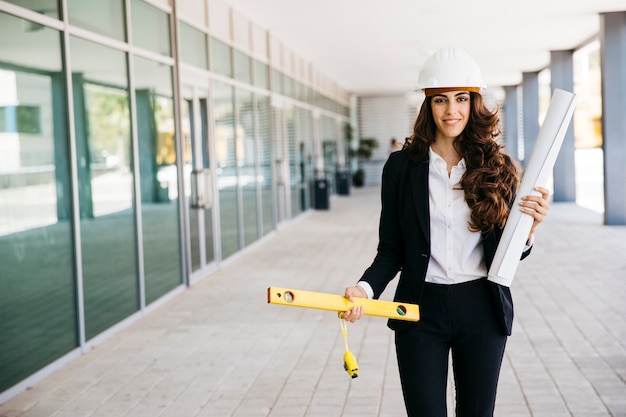 Mujer de negocios amable con plano y nivel