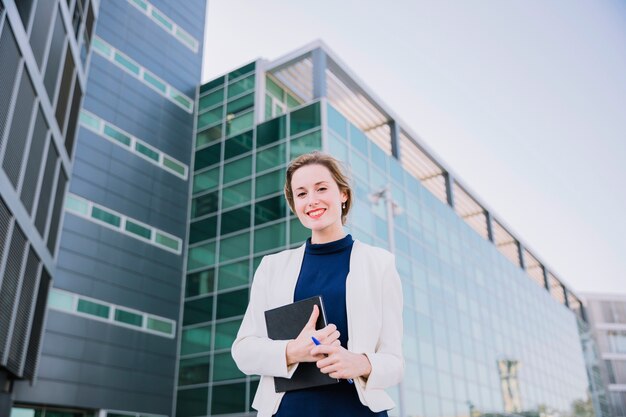 Mujer de negocios amable sujetando libro