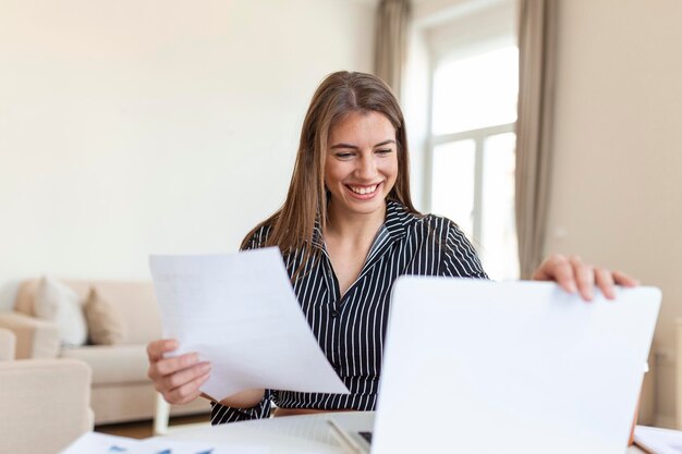 Mujer de negocios analizando datos usando la computadora mientras pasa tiempo en la oficina Hermosa joven mujer profesional sonriente en la oficina Gráficos y tablas