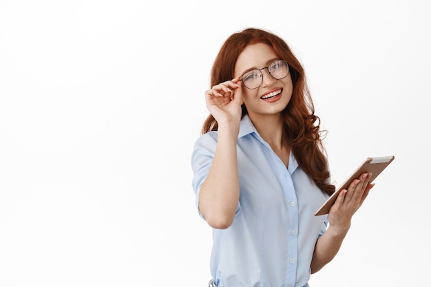 mujer de negocios, en, anteojos, y, tenencia, tableta, posar, blanco