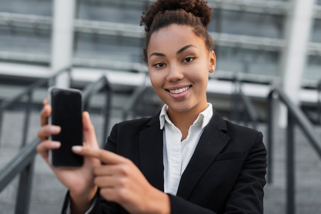 Mujer de negocios apuntando al teléfono