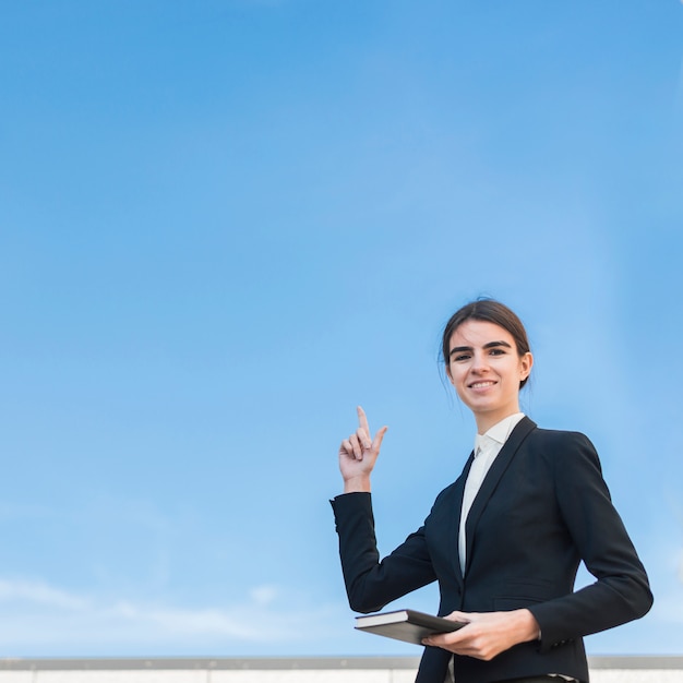 Mujer de negocios apuntando hacia arriba