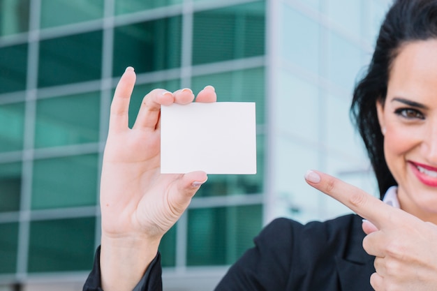 Mujer de negocios apuntando hacia tarjeta de visita