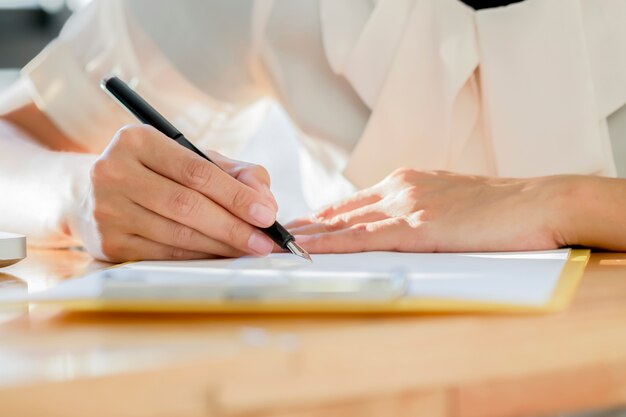 Mujer de negocios de Asia firmar un documento de contrato haciendo un trato.