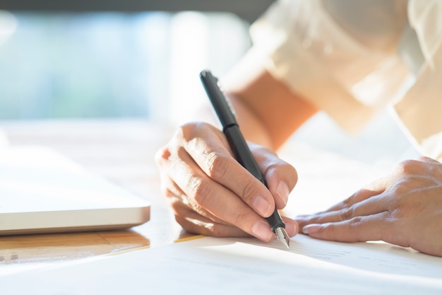 Mujer de negocios de Asia firmar un documento de contrato haciendo un trato.