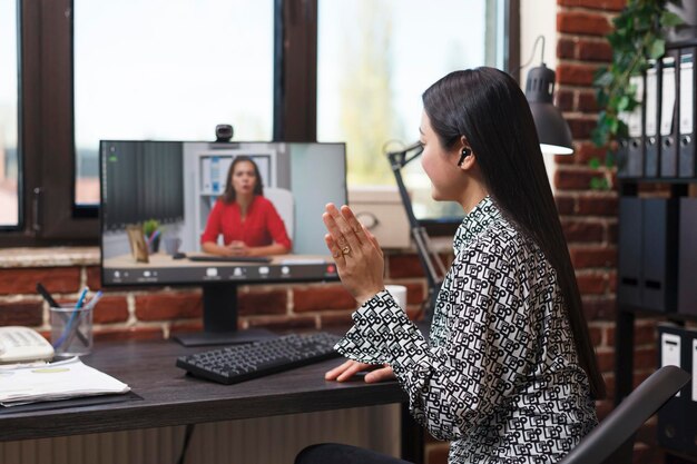 Mujer de negocios asiática saludando en una conferencia digital de videollamada de cámara web con el gerente general hablando sobre problemas financieros de negocios. Contador asiático informando a un superior sobre un inicio fallido.