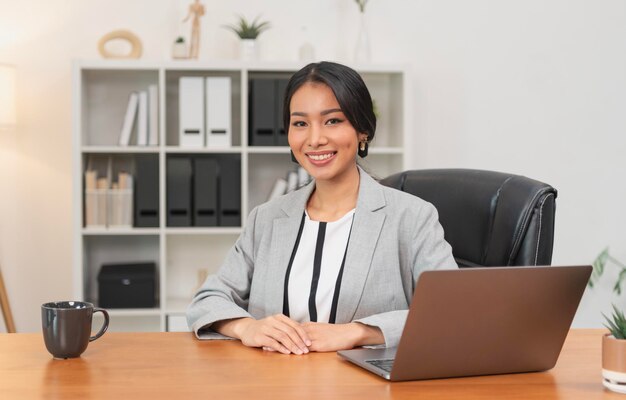 Mujer de negocios asiática sentada en la oficina