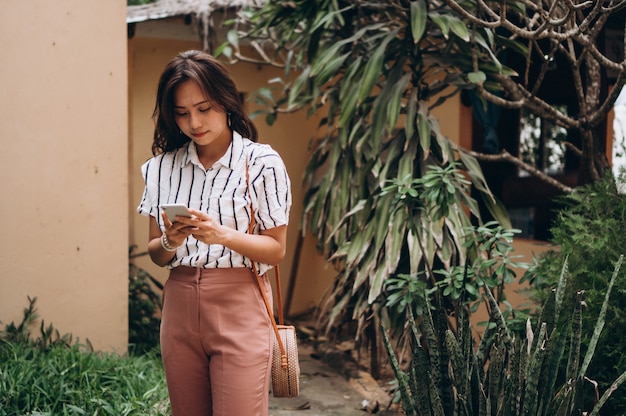 Mujer de negocios asiática de vacaciones hablando por teléfono