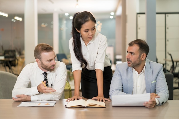 Mujer de negocios asiáticos trabajando con compañeros de trabajo en el escritorio