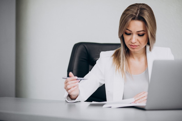 Mujer de negocios atractiva que trabaja en la computadora en la oficina