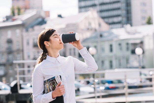 Mujer de negocios bebiendo café al aire libre