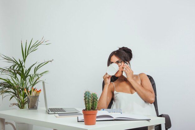 Mujer de negocios bebiendo café en el trabajo