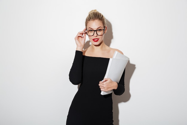 Mujer de negocios de belleza en vestido y anteojos con documentos