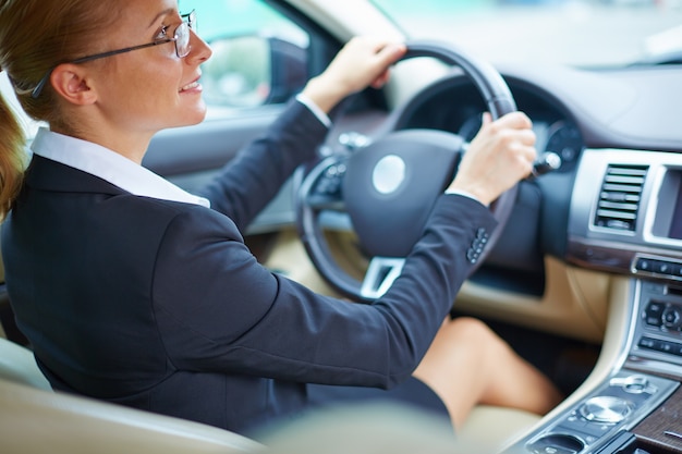 Mujer de negocios bien vestida conduciendo