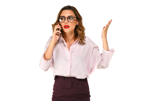 Mujer de negocios bonita joven hablando por el teléfono móvil, se ve confundido