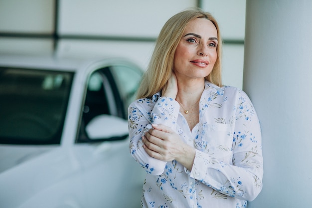 Mujer de negocios buscando coche en una sala de exposición de automóviles