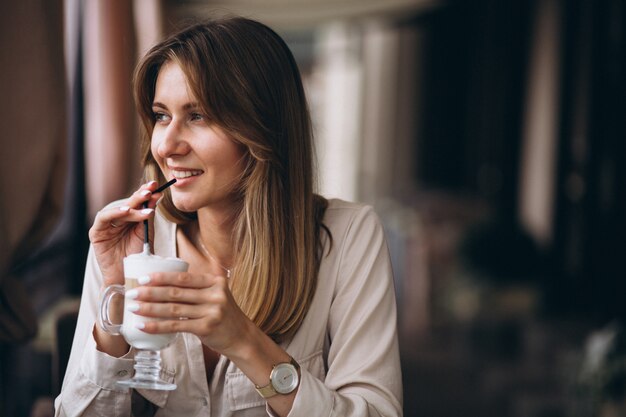 Mujer de negocios en un café bebiendo café con leche