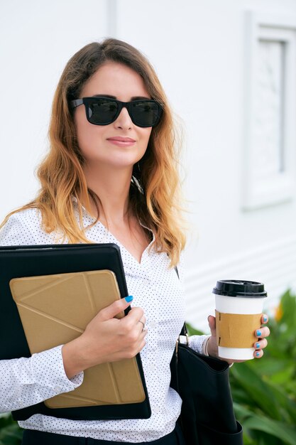 Mujer de negocios con café desechable