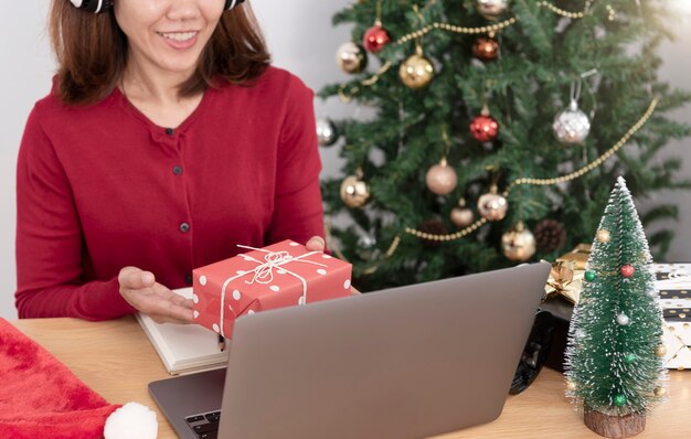 Mujer de negocios con caja de regalo en la mesa de oficina en el día de Navidad.