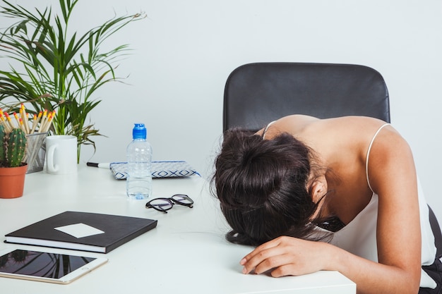 Foto gratuita mujer de negocios cansada apoyando la cabeza en la mesa