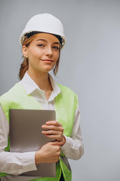 Mujer de negocios en casco usando laptop