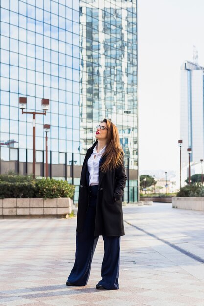 Mujer de negocios en la chaqueta elegante que se coloca afuera