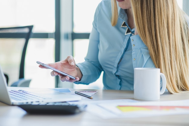 Mujer de negocios controlando smartphone vista de cerca