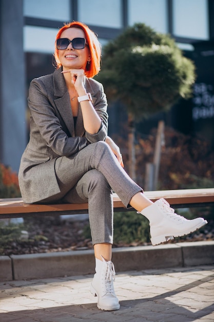 Mujer de negocios de edad avanzada en traje gris al aire libre