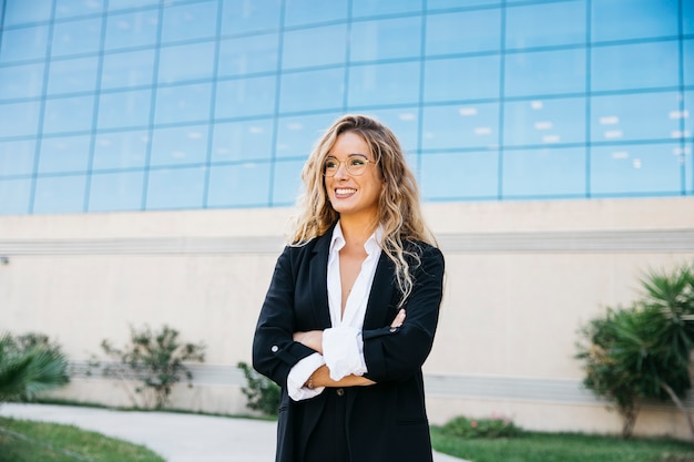 Mujer de negocios elegante enfrente de edificio de cristal