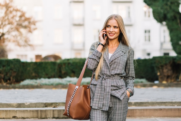 Mujer de negocios elegante haciendo llamada en ciudad