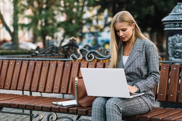 Mujer de negocios elegante sentada en banco