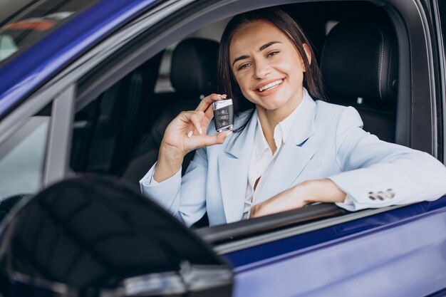 Mujer de negocios eligiendo un coche en una sala de exposición de coches