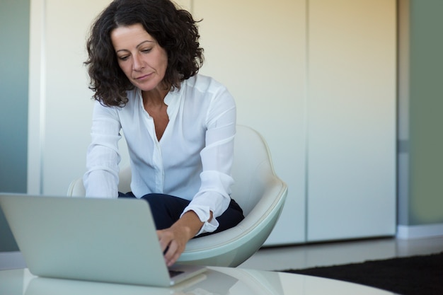 Mujer de negocios enfocada trabajando mientras espera socios